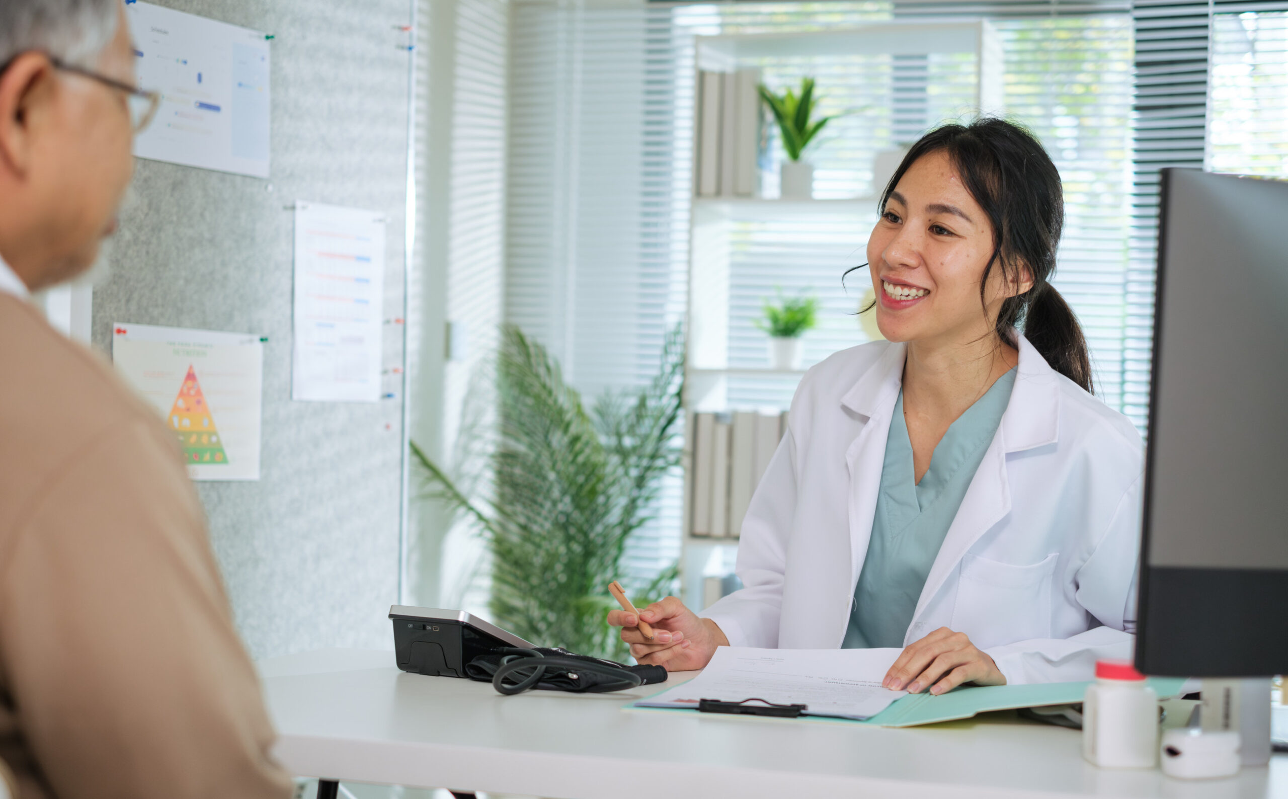 Doctor shaking hand with hospital manager, standing in hospital hallway.